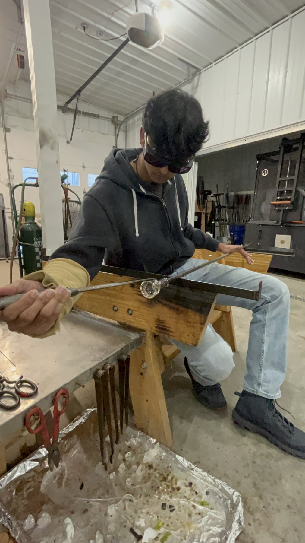 Shaping hot glass at the glassblowing bench